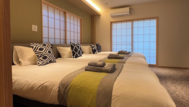Een hotelkamer met twee bedden, een groot raam en een airconditioning.