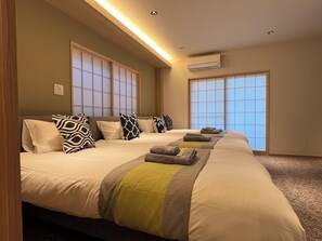 Une chambre d’hôtel avec deux lits, une grande fenêtre et un appareil de climatisation.