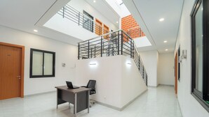 Un interior moderno con un escritorio, una silla y una escalera que sube a un nivel superior.
