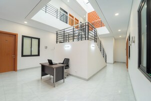 Un interior moderno con un escritorio, una silla y una escalera que sube a un nivel superior.