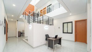 Un interior moderno con una escalera, un escritorio y una computadora.