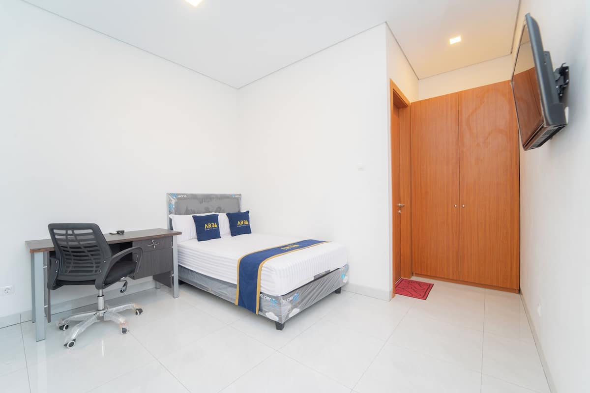 Un dormitorio con cama, escritorio, silla y armario.