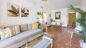 Ein modernes Wohnzimmer mit Sofa, Couchtisch und Essbereich.