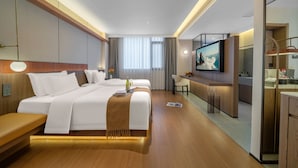 Una habitación de hotel moderna con una cama grande, un escritorio y un televisor.