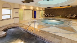 A spa area with a hot tub, lounge chairs, and a small waterfall feature.