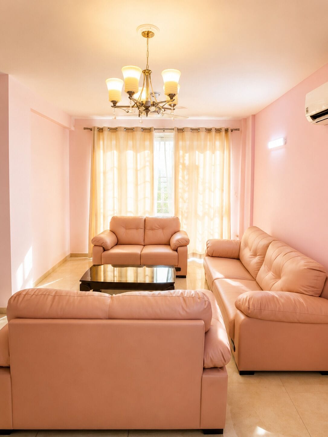 A living room with a sofa set, a coffee table, and a chandelier.