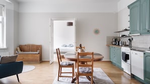 Una cocina moderna con armarios de madera, una mesa de comedor con sillas y una zona de estar acogedora con un sofá y un banco.