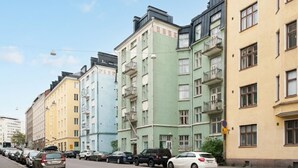 Una hilera de edificios residenciales de varios pisos con balcones y una calle al frente.