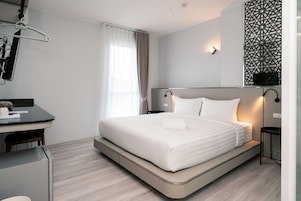 Una habitación de hotel moderna con una cama, un escritorio y una silla.
