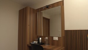 A wooden desk with a mirror, a kettle, and a glass pitcher. - Grand Sea Way (Chennai)