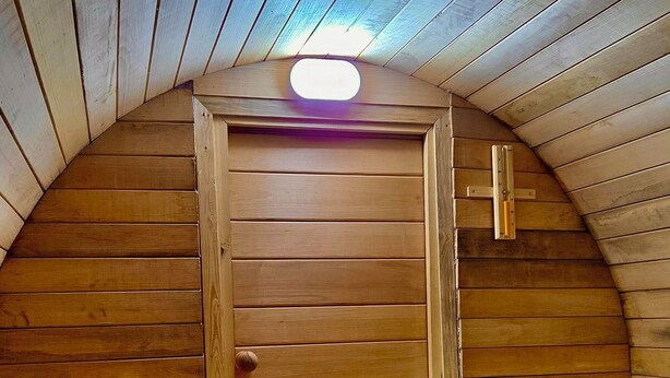 Eine Sauna mit Holzwänden und einer geneigten Decke.