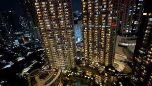 A high-rise building complex at night with illuminated windows, a central courtyard, and surrounding roads. - Premium Taman Anggrek Residences (West Jakarta)