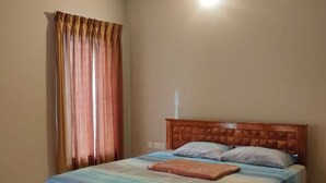A bedroom with a wooden bed, a ceiling fan, and a window with curtains. - 2D-Villastay (Kovalam)