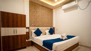 Una camera da letto con un letto, un'armadio in legno e un condizionatore.