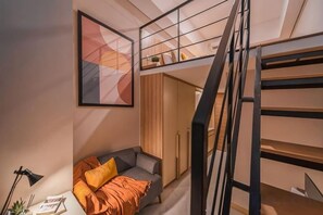A loft-style bedroom with a bunk bed, a desk, and a bookshelf. - Cove Prima (South Jakarta)