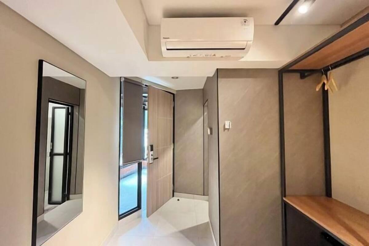 A modern hallway with a mirrored wall, a built-in bench, and an air conditioning unit.