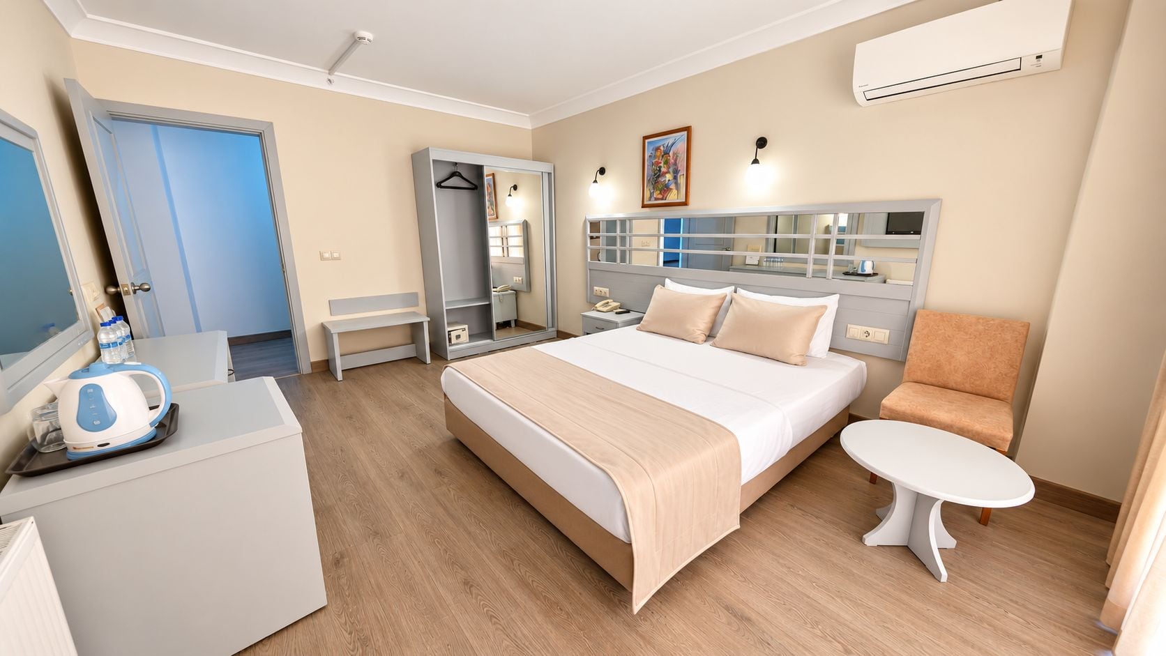 Una habitación de hotel con cama, mesita de noche, silla, armario y televisión.
