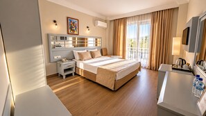 Habitación de hotel con una cama grande, mesitas de noche, un escritorio con silla y vistas al exterior.