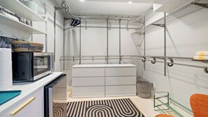 Une cuisine compacte équipée d’un four à micro-ondes, de tiroirs de rangement et d’un tapis à motifs.