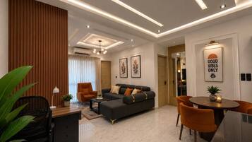A modern living room with a sofa, coffee table, and dining area.