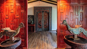 A wooden hallway with ornate doors and a ceiling with exposed beams. - Yara Wellness (Buwit)