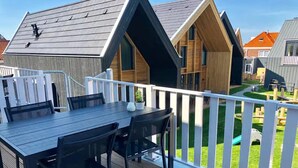 En terrass med ett bord och stolar, med utsikt över ett bostadsområde med hus.