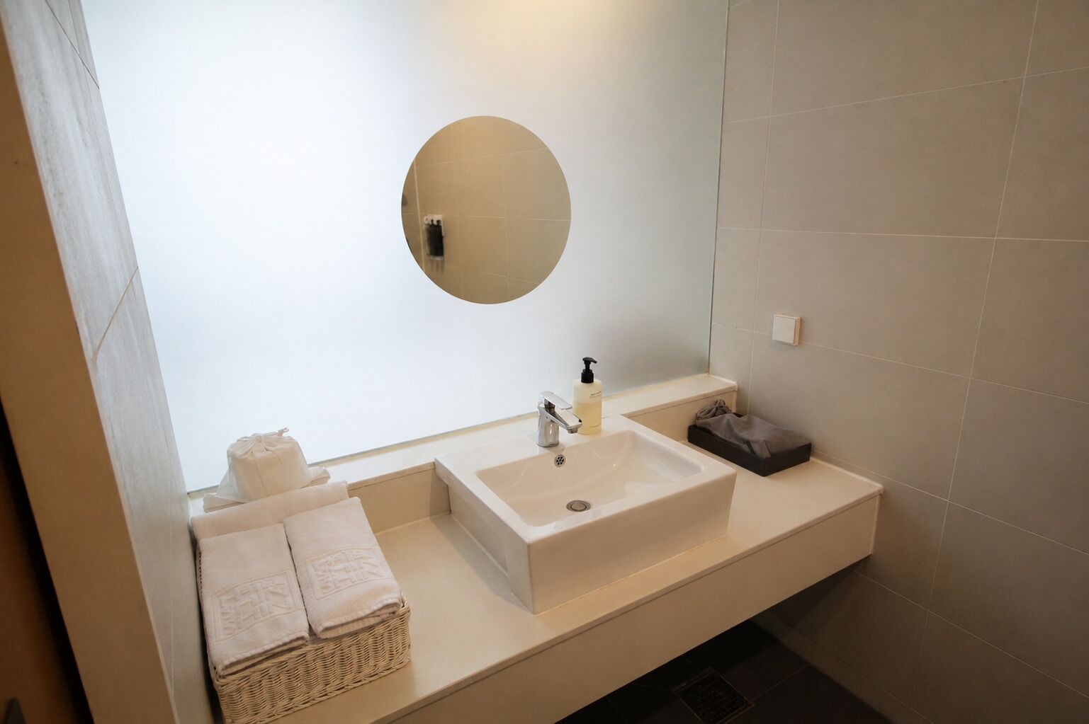 A modern bathroom with a large mirror, two sinks, and a towel rack.