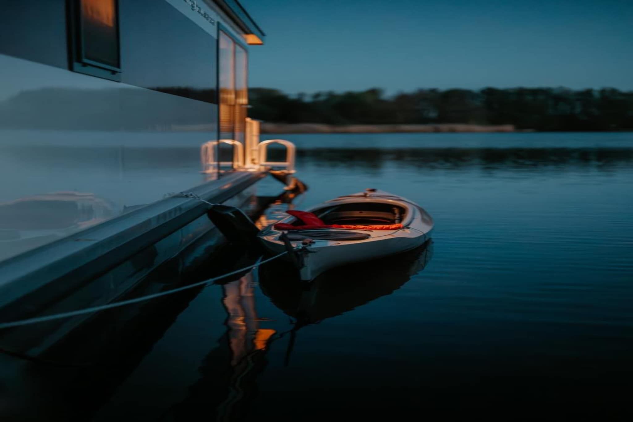 A boat docked at a marina with a building in the background.