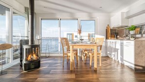 A modern kitchen with a large island, a built-in stove, and a view of the water. - Bright Base with Coastal Access (Ribnitz-Damgarten)