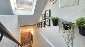 A room with a skylight, framed pictures, and hanging plants. - Apartment Turmblick - Comfortable apartment in the center of Marienhafe with (Marienhafe)