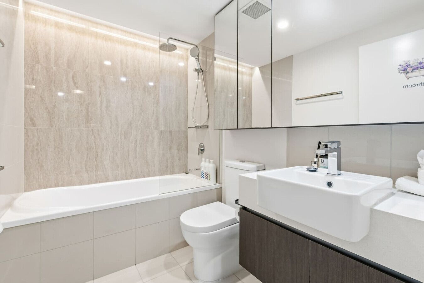 A modern bathroom with a bathtub, a toilet, and a sink.