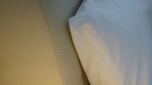 A close-up of a sofa with a visible seam and a lamp with a white shade. - Modern 1BR Apartment | Convenient Stay (MacGregor)