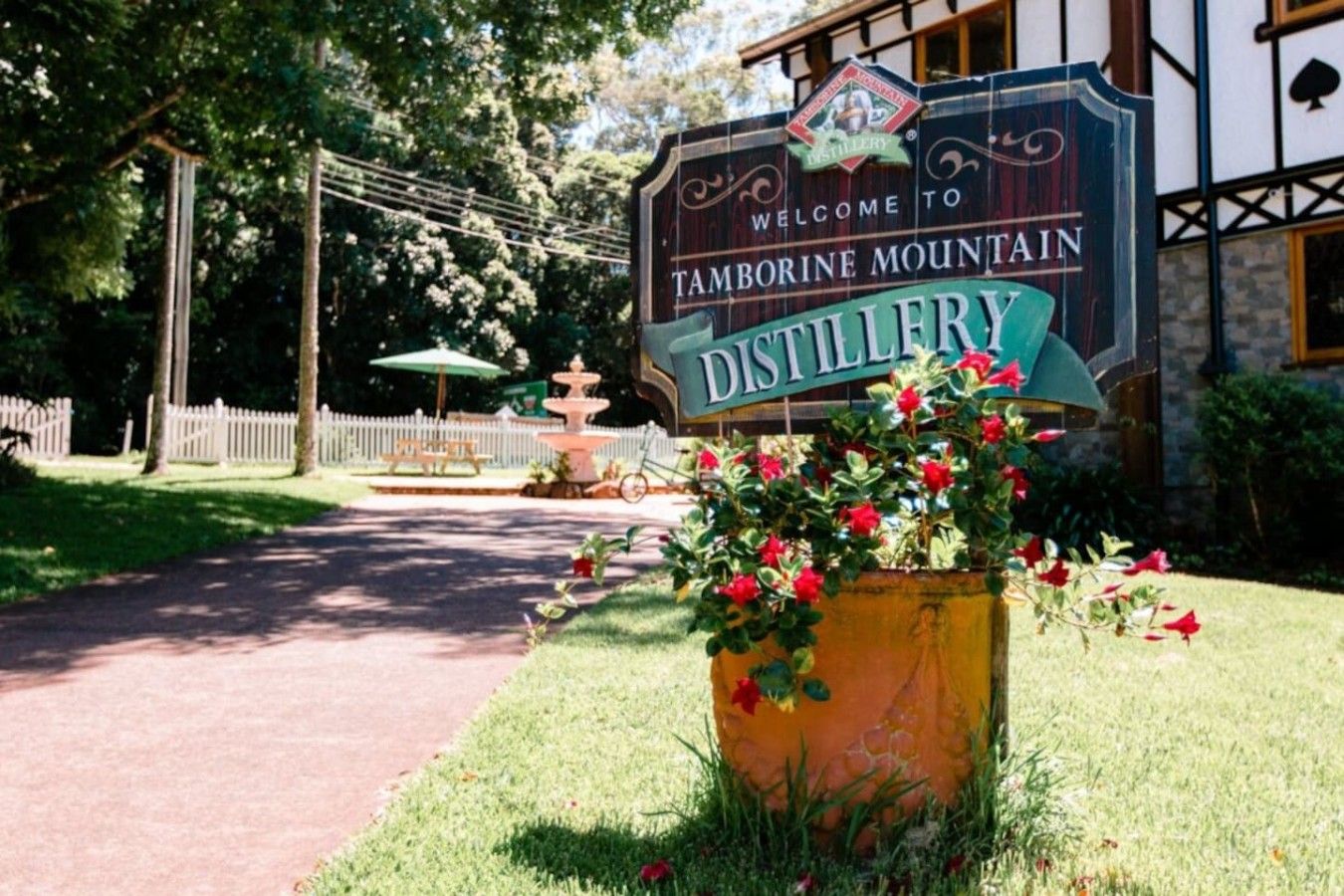 Ein Schild für die Tamborne Mountain Distillery, mit einem Weg, der dorthin führt.