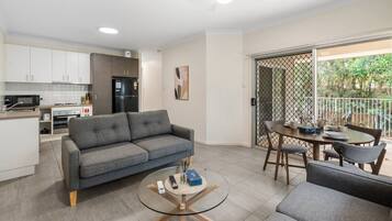 A modern living area with a sofa, coffee table, and dining set.