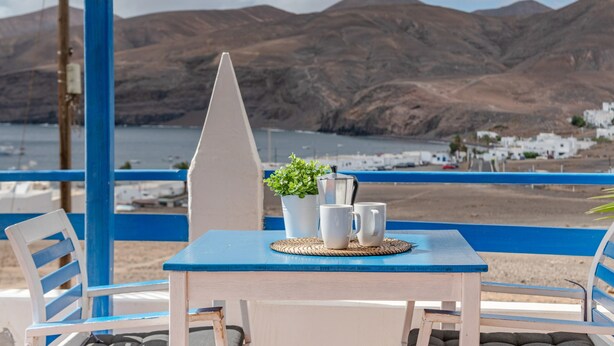 A table with a plant, two white mugs, and a coffee pot. - Unit 1 with Sea View, Shared Terrace and Wi-Fi (Yaiza)