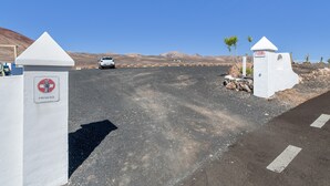 A parking area with a white car, a 'PARKING' sign, and a 'PRIVADO' sign indicating private access. - Unit 1 with Sea View, Shared Terrace and Wi-Fi (Yaiza)