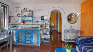 A kitchen with a blue and white tiled backsplash, a central island, and a dining area with a blue table and chairs. - Unit 1 with Sea View, Shared Terrace and Wi-Fi (Yaiza)