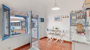 Een keuken met een eethoek, een raam met blauwe randen en uitzicht op het exterieur.