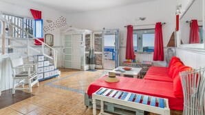 Ein geräumiges Zimmer mit Treppe, Essbereich und einer Couch.