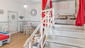 Ein Zimmer mit Etagenbett, Schreibtisch, Stuhl und kleinem Tisch.