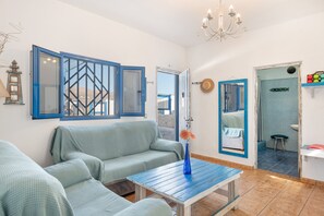 Een woonkamer met een bank, een bijzettafeltje en een kroonluchter.