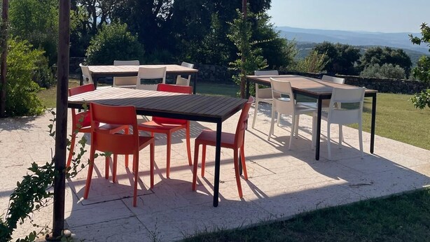 Ulkoterassi, jossa on pergola, pöytiä ja tuoleja.