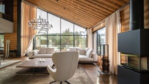 Ein modernes Wohnzimmer mit großem Fenster, Kamin und einer Couch.
