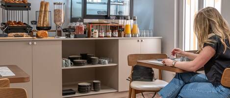 Un banco colazione con pasticcini, condimenti e bevande.