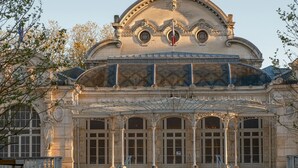 A historic building with ornate architecture, large windows, and a covered entrance area. - The Originals City Hôtel Harys (Vichy)