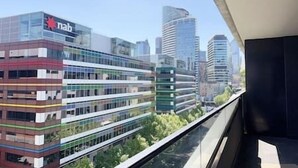 Un edificio moderno con facciata in vetro e il logo 'nab', circondato da grattacieli.