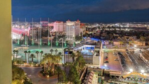 Un hotel con parcheggio, area piscina e vista sulla città di notte.