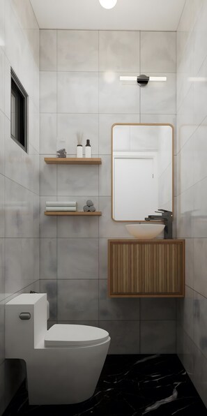 Une salle de bain moderne avec des toilettes, un lavabo et un miroir. On peut voir des étagères en bois au-dessus du lavabo et une porte au fond.