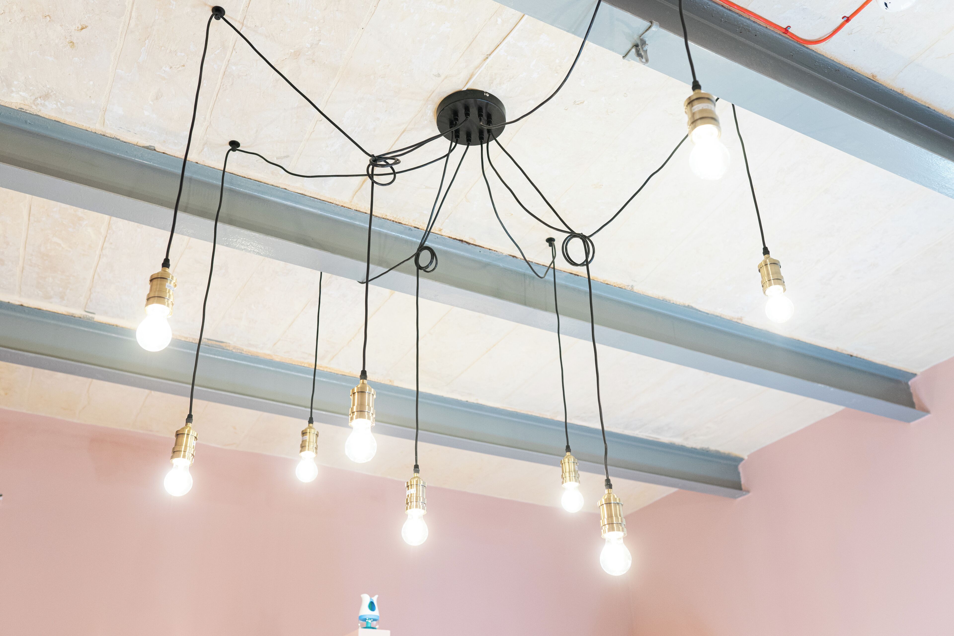 A ceiling with exposed beams and hanging light fixtures.