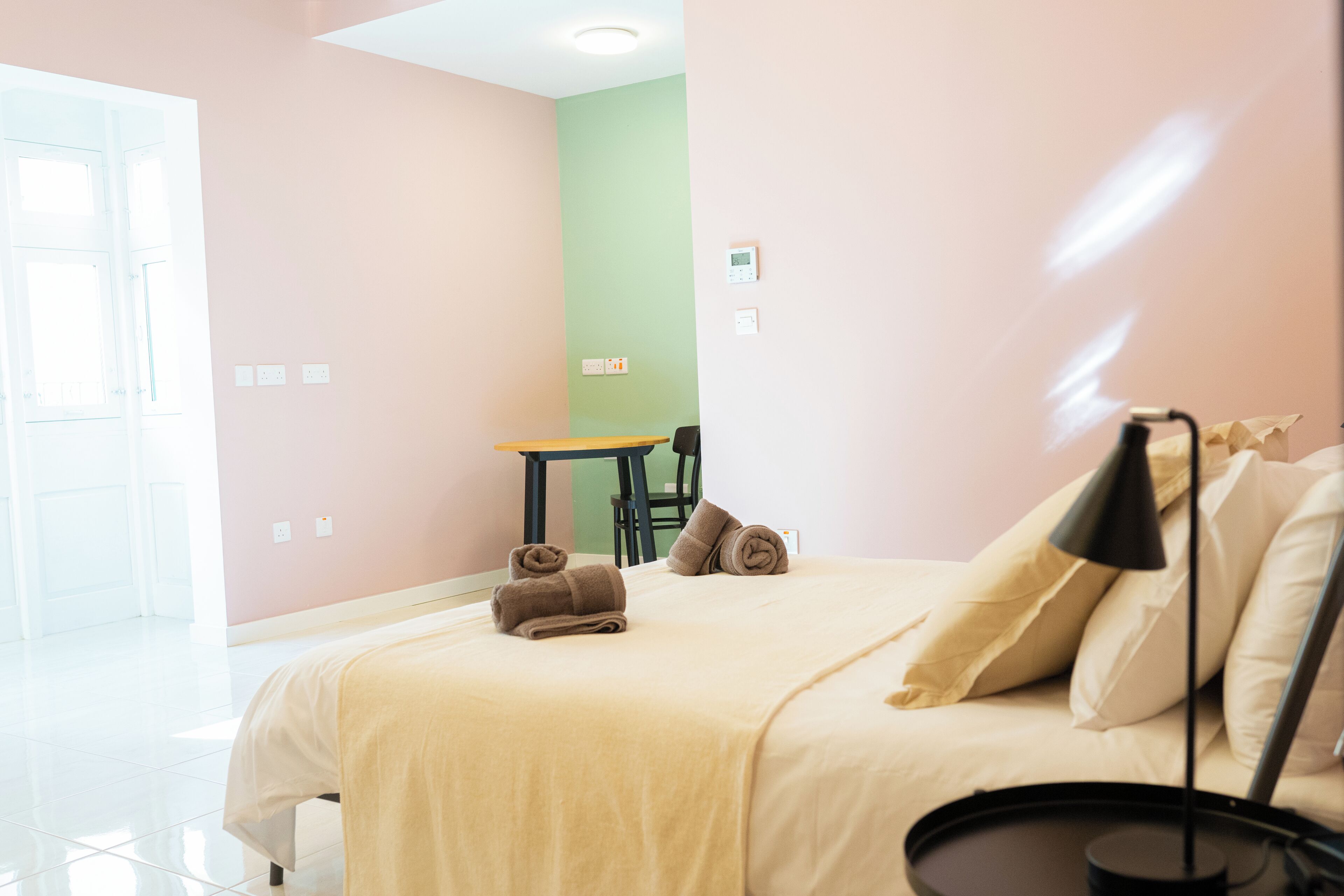 Una habitació d'hotel amb un llit, una taula de treball i una cadira.